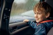 © alisaaa - Little boy travelling in car on a rainy day Kids aged 7 is looking out of the car window. The glass is covered by rain drops.