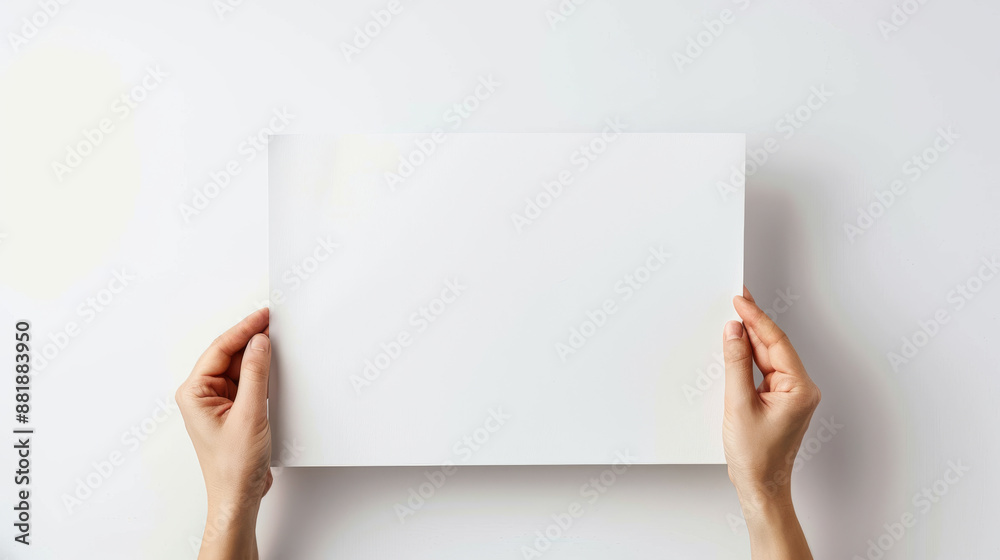 Two hands holding up a blank white sheet of paper against a stark white ...