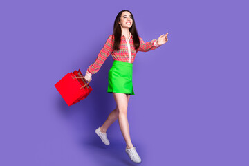 Poster - Full body photo of attractive young woman run jump shopping bags dressed stylish pink clothes isolated on violet color background