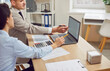 © Studio Romantic - Office colleagues working together on business accounting, gathered around a laptop. Collaboration, teamwork, and active discussion among colleagues during work meeting in a professional setting.