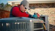 © Photock Agency - HVAC Technician Working on an Air Conditioner