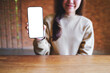 © Farknot Architect - Mockup image of a young woman holding and showing a mobile phone with blank white screen