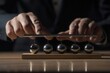 © furyon - sleek newtons cradle on polished wooden desk male hand initiating motion dramatic lighting emphasizes steel balls gleam symbolizing business momentum and decisionmaking dynamics