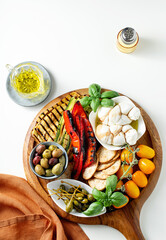 Wall Mural - Board with ITALIAN summer foods and grilled vegetables: mozzarella braid, cherry tomatoes, grilled eggplant and zucchini, olives and capers