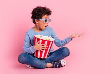 Poster - Full length photo of funky cool son dressed blue sweatshirt enjoying film eating pop corn showing arm emtpy space isolated pink color background