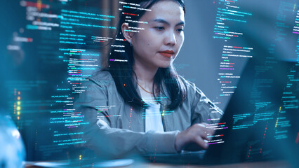 An Asian woman works with a laptop, surrounded by abstract holographic code. Concepts of software development and coding.