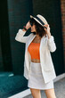 © Bliss - A woman in a white blazer and skirt enjoys her trip through Europe.