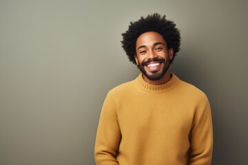 Poster - Portrait of a smiling afro-american man in his 30s dressed in a warm wool sweater isolated on plain cyclorama studio wall