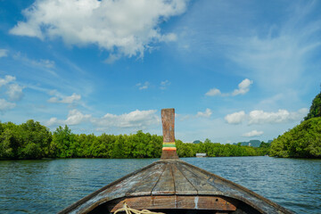 Longtail Boat in Andaman sea, Krabi Thailand. Sailing ship and traditional boat. View from a traditional Thai wooden prow boat while floating in the bay provides a tourist with beautiful scenery.