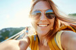 © vejaa - Happy girl is traveling in nature on beautiful summer day. Young woman blogger taking selfie, streaming online, recording videos with her smartphone. Summer, vacation, solo travel, holiday, trip