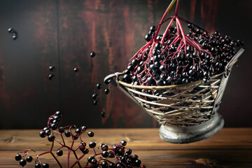 Wall Mural - elderberries in a basket on a wooden table