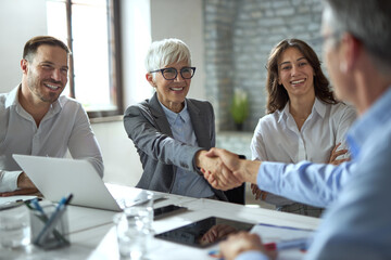 Happy businesswoman shaking hands on a meeting in the office. 