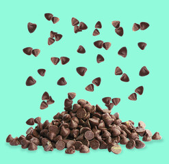 Wall Mural - Sweet chocolate chips falling on turquoise background