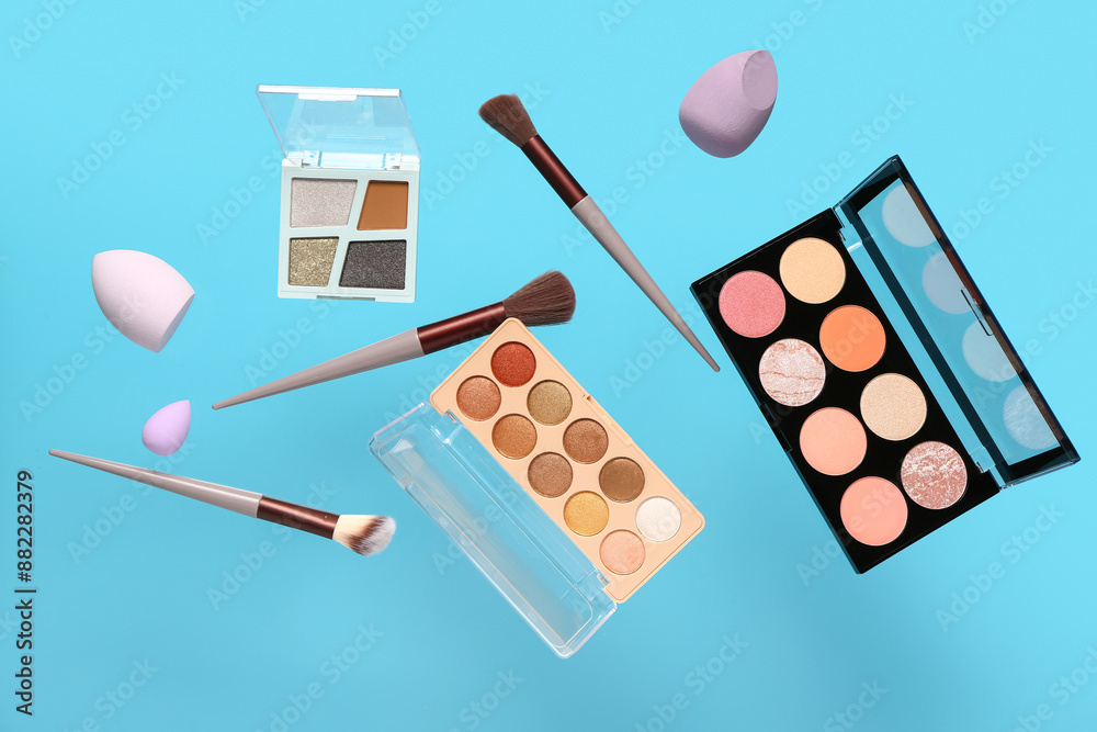 Flying decorative cosmetics on blue background