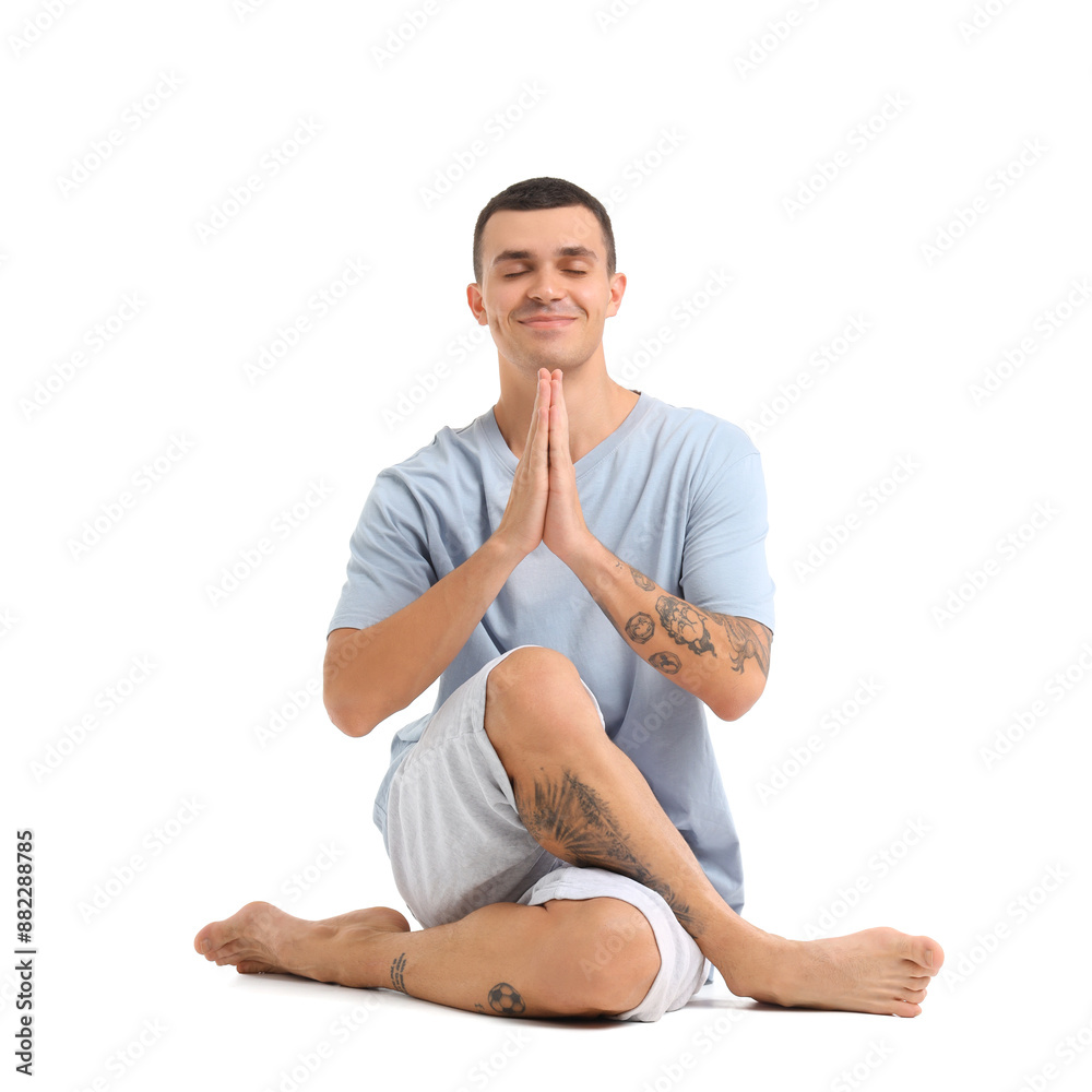 Young man doing yoga on white background
