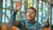© mikhailberkut - Middle-Aged Man Raising Hand in Public Space Among Others