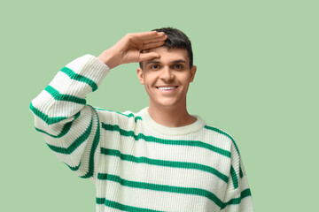 Wall Mural - Young deaf mute man using sign language on green background