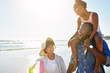 © ReeseArcurs/peopleimages.com - Family, girl and parents piggyback on beach for holiday, vacation and travel with summer, trip and support. African child, dad and mom or excited people laughing, talking and bonding by ocean