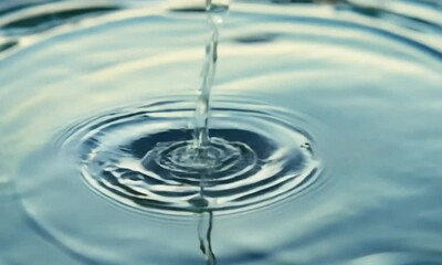 Poster - Gentle water droplets form abstract shapes on a serene blue background, evoking purity and freshness in nature