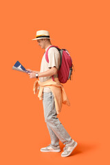 Poster - Young male tourist with backpack and map on orange background