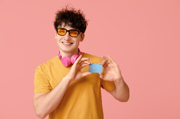 Sticker - Young man in sunglasses with credit card on pink background