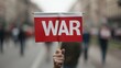 © top images - A person holding a red and white flag with the word war written on it