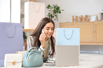 Sticker - Young woman with mobile phone and laptop shopping online on floor at home