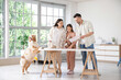 © Pixel-Shot - Happy family with paint color palettes and dog during repair of their new house