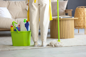 Poster - Female janitor with mop and cleaning supplies in room, back view