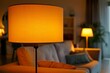 © Elmira - A modern lampshade with a warm, soft light illuminates a cozy living room setting. The light creates a relaxing and inviting atmosphere in the space