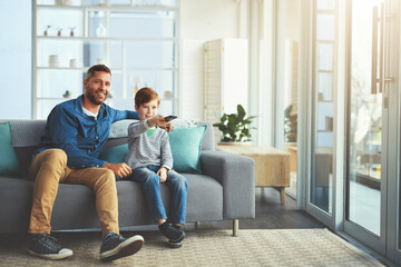 Canvas Print - Father, child and watching tv with remote on sofa for movie, cartoon or online subscription at home. Happy dad, son or kid in relax with smile for series, entertainment or bonding together at house