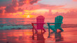 © Tijana - Two colorful Adirondack chairs, one pink and one teal, on a beach facing the ocean during a vibrant sunset with dramatic clouds.