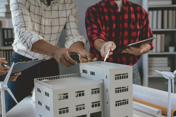 Wall Mural - architects are working together in the office using a scale model of a building to make calculations