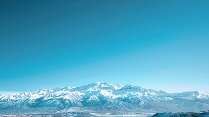 Poster - A panoramic view of snow-capped mountains with a clear blue sky.