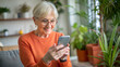 © NewFresh  - Portrait of senior woman using smartphone while sitting on sofa at home