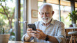 © NewFresh  - Senior man using mobile phone in a coffee shop. Selective focus.