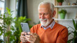© NewFresh  - Senior man using smartphone at home. Elderly man using mobile phone.