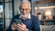 © NewFresh  - Portrait of senior man using smartphone while sitting on sofa at home