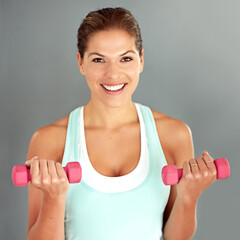 Poster - Portrait, dumbbells and woman with wellness, workout and exercise on grey studio background. Face, healthy person and athlete with equipment, fitness and training with muscle, energy and challenge