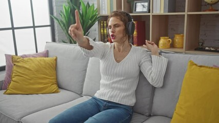 Sticker - Young caucasian woman dancing joyfully at home while listening to music through headphones