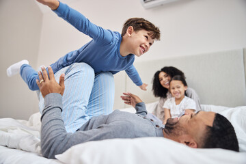 Canvas Print - Family, parents and children in bedroom, airplane and time together with happiness, relax and smile. Home, mother and father with kids, flying and cheerful with fun, playful and imagination with joy