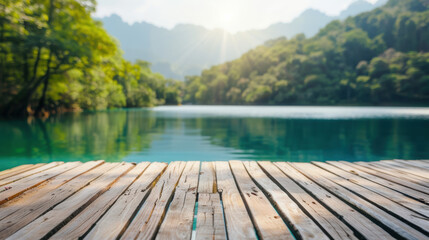 Poster - Serene wooden dock by a tranquil turquoise lake with lush green forested mountains in the background under bright morning sunlight.