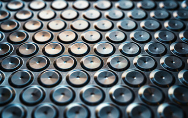 Poster - Close-up of a grid of metal buttons with a reflective surface, arranged in a uniform pattern, perfect for industrial, technology, or abstract themes.