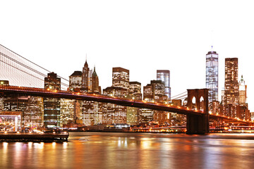 Canvas Print - A vibrant night view of Manhattan skyline with the Brooklyn Bridge, illuminated buildings, and reflections on water