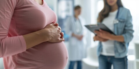 Preparing for baby birth. Close-up of a pregnant woman holding her belly having an appointment with a doctor at an antenatal clinic prenatal healthcare center.