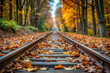 © Butsarakham - The train tracks are covered in autumn leaves, creating a serene and peaceful atmosphere. The leaves are scattered along the tracks, giving the impression of a journey through a beautiful