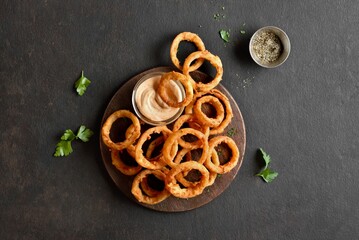 Wall Mural - Heap of deep fried onion rings on wooden serving dish