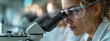 © Анна Мартьянова - caucasian, european scientist looks into the microscope, focused and purposeful. healthcare professionals concept. banner
