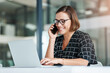 © Hira/peopleimages.com - Typing, woman and phone call in office with laptop for work as receptionist, administrative support and multitasking skill. Female employee, online and speaking to confirm appointment and planning.