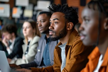 Wall Mural - A group of professionals, including a young Black entrepreneur and a middle-aged Asian manager, listen intently during a business meeting